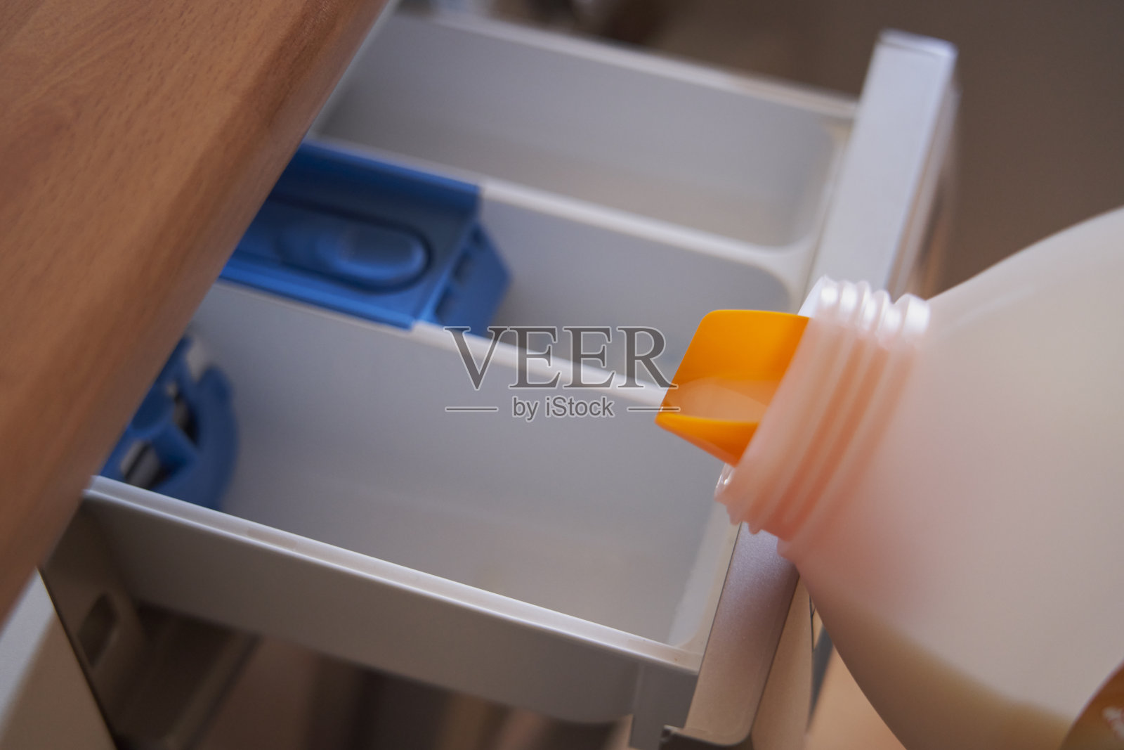 特写镜头:往洗衣机里倒洗涤剂照片摄影图片