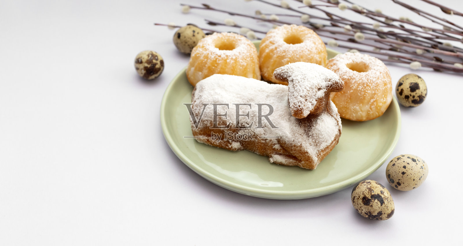 特写复活节甜羊磅蛋糕洒上糖粉,鹌鹑蛋,复活节纸杯蛋糕或巴贝茨基绿盘,柳枝。传统的复活节食物概念。水平面。本空间照片摄影图片