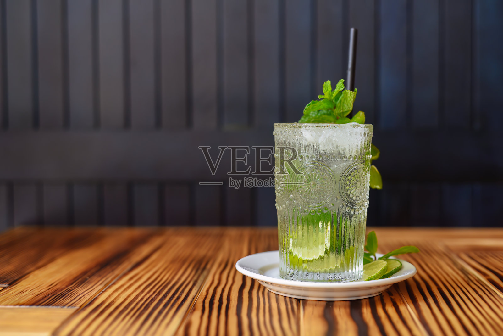 酒精鸡尾酒莫吉托在木桌对着黑暗的墙壁与复制空间照片摄影图片
