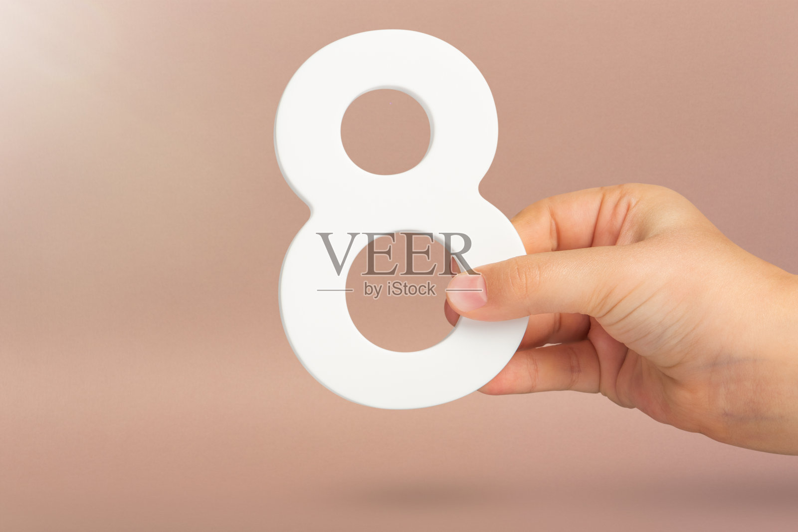 手里有八个。一只手拿着红色背景上的白色数字8。8号概念车。生日8年,百分比,八年级还是天,国际妇女节。照片摄影图片