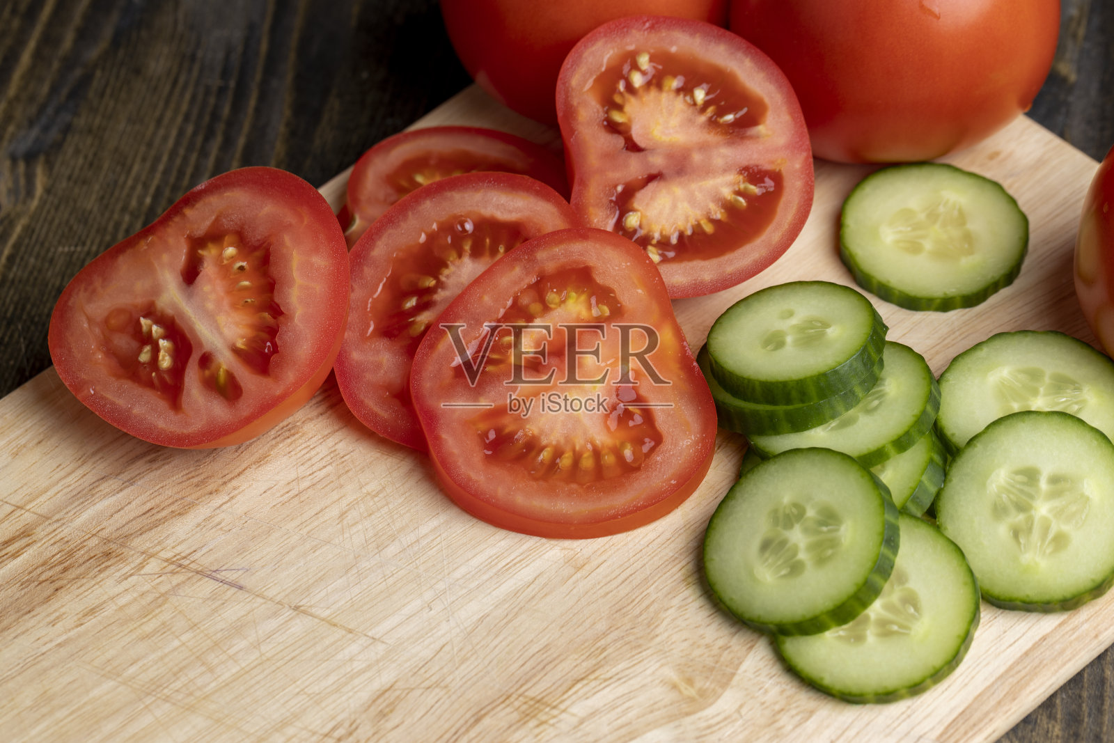 将成熟的红番茄切成片放在板上照片摄影图片