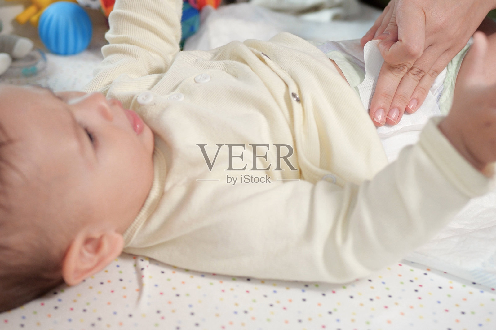 妈妈在桌子上给婴儿换尿布,特写照片摄影图片