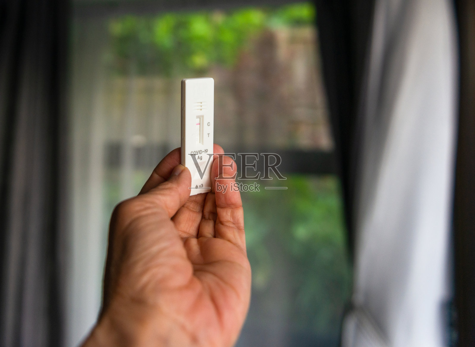 Covid-19检测结果阴性,自检试剂盒上显示一条红色条。在家拿着检测试剂盒。奥克兰。照片摄影图片