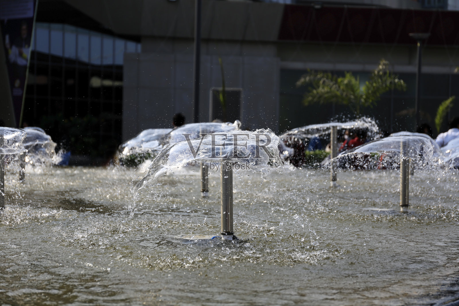 池塘里的喷泉反射着阳光照片摄影图片