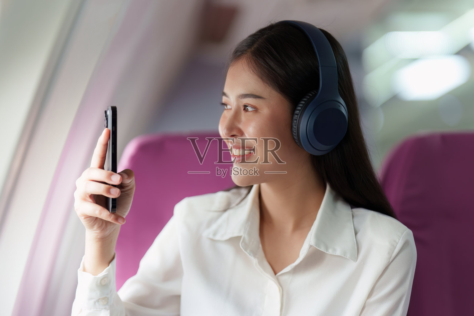 美丽的亚洲女商人在飞机上用手机拍照。工作、旅游、创业理念照片摄影图片