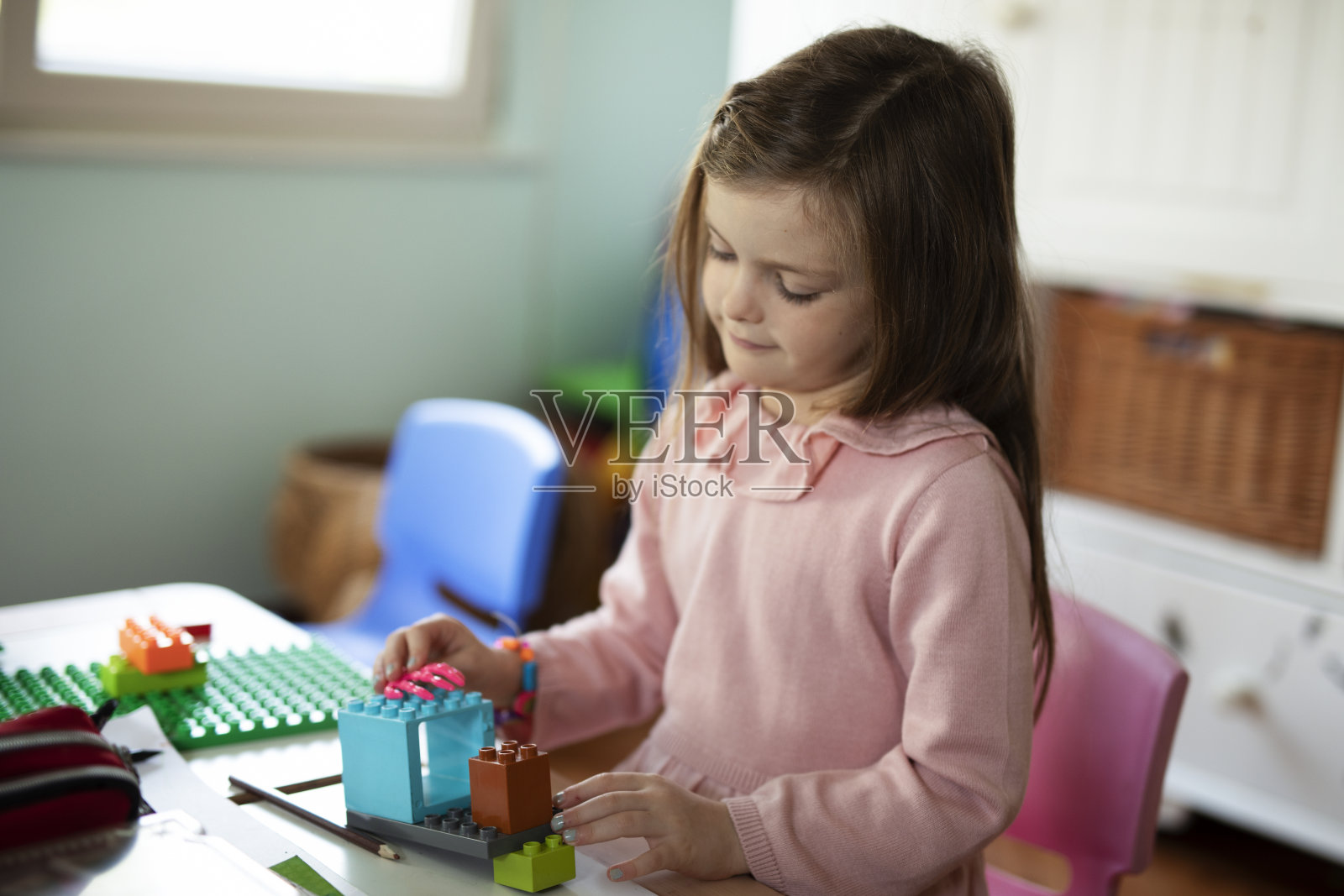 小孩子在室内玩许多玩具。照片摄影图片