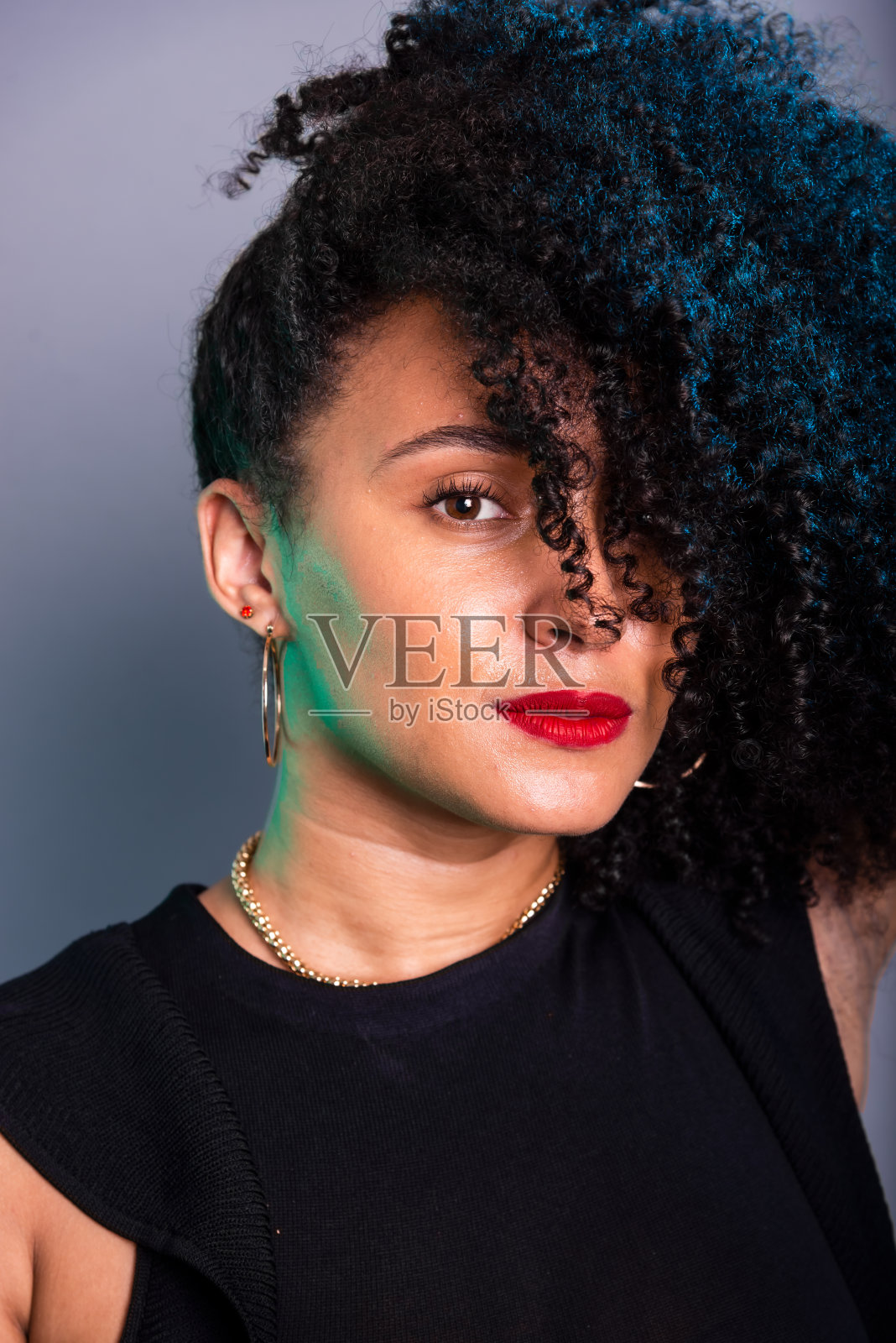 美丽的年轻女子的垂直特写肖像,头发遮住了她的脸。照片摄影图片