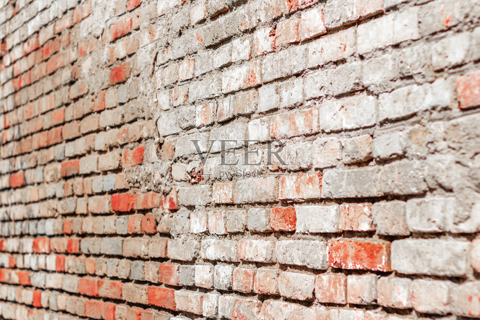 墙是用红灰相间的旧砖砌成的。照片摄影图片