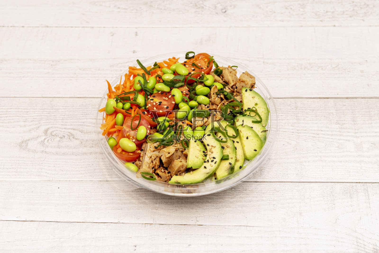 碗里有纯素鸡肉替代品,樱桃番茄碎,胡萝卜丝,毛豆,鳄梨片和白米底照片摄影图片