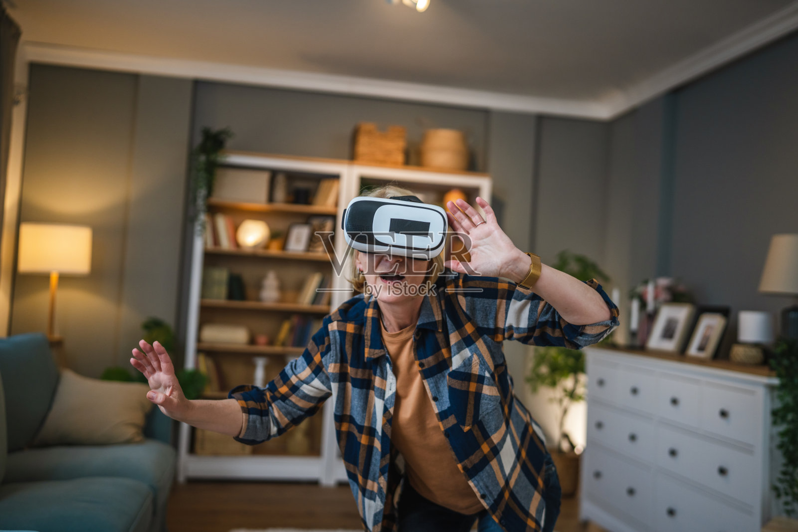 女性成熟老年女性在家享受虚拟现实VR耳机照片摄影图片