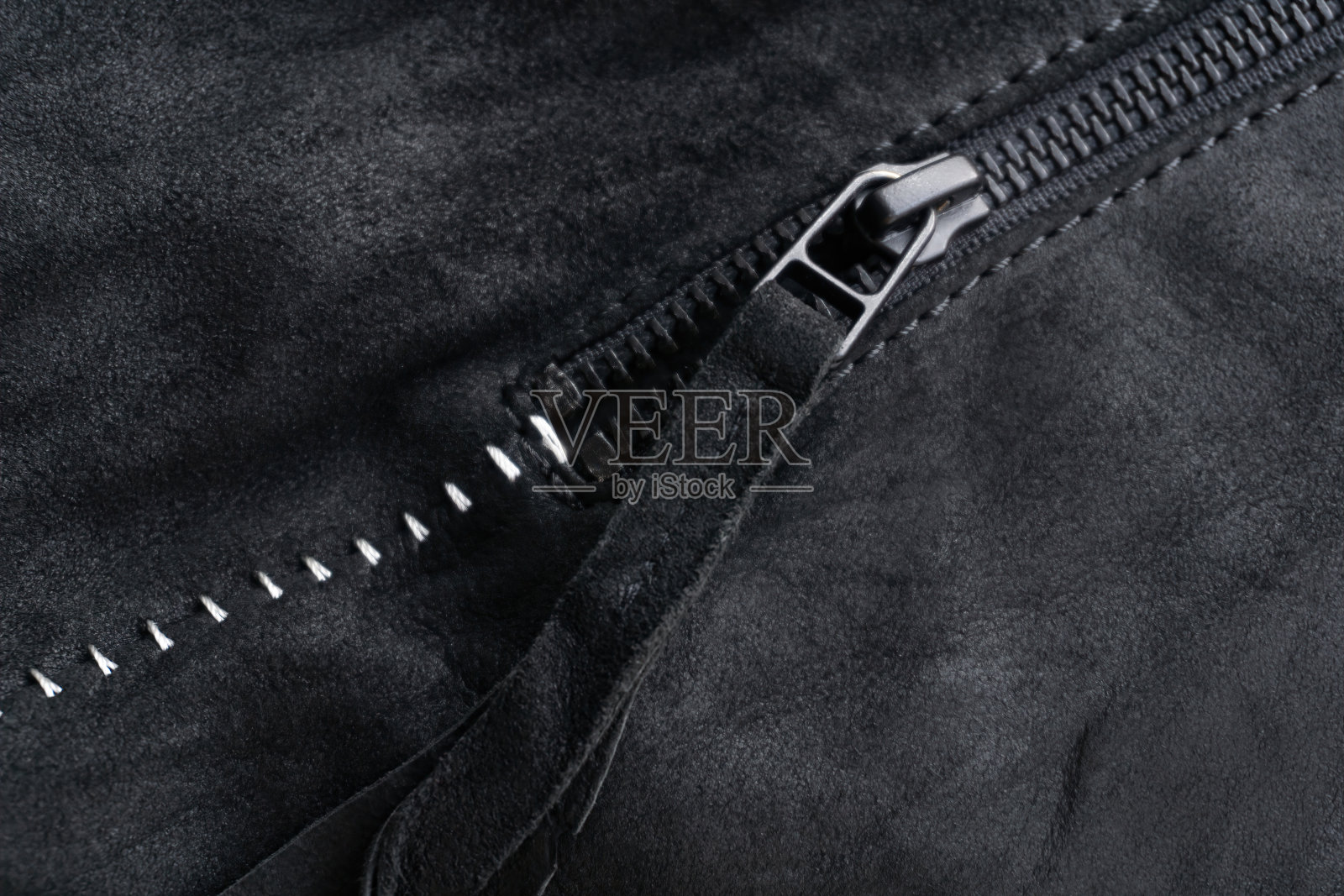 拉链与标签上的黑色麂皮夹克与白色对比接缝照片摄影图片