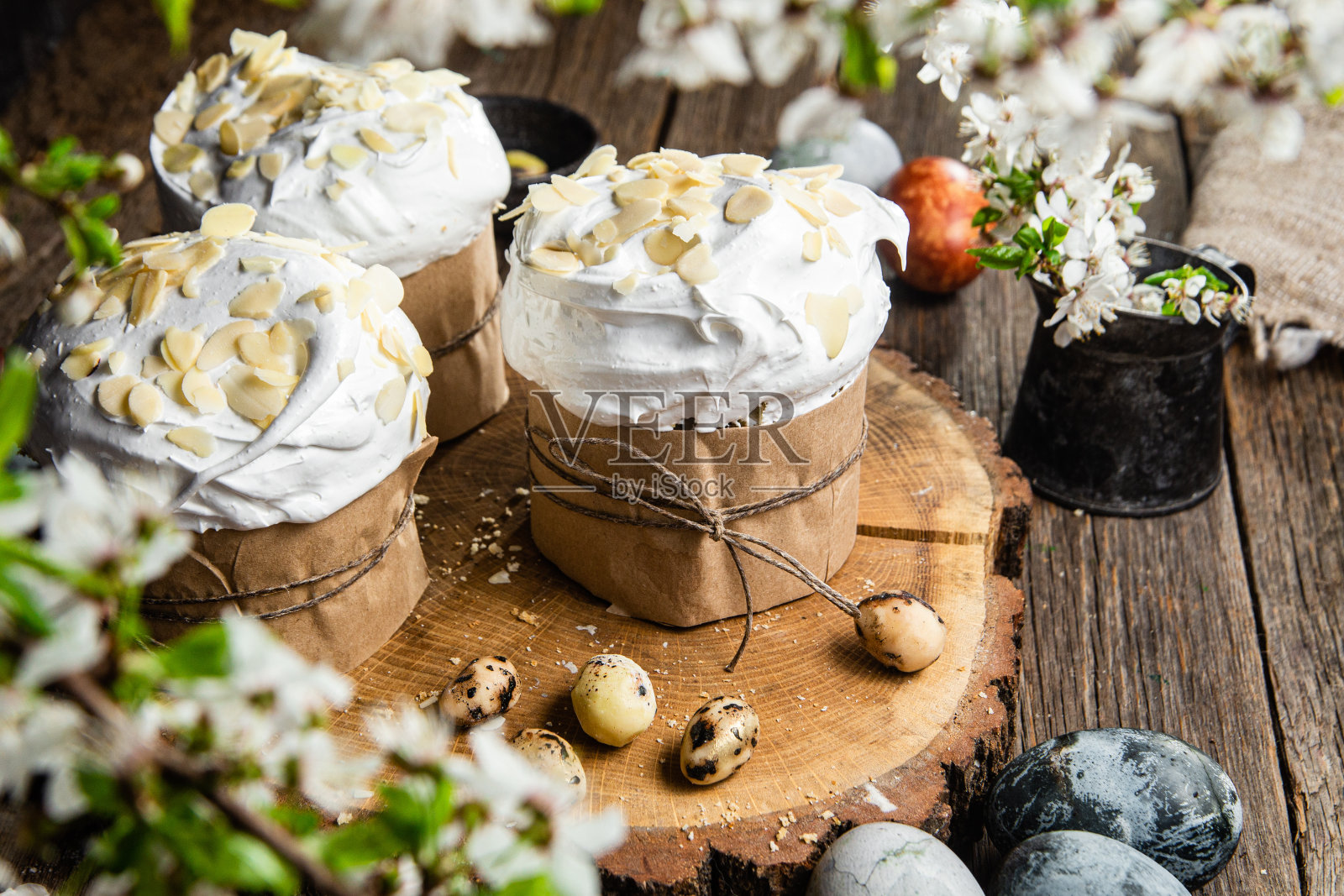 木制背景上有蛋白霜和杏仁花瓣的复活节纸杯蛋糕照片摄影图片