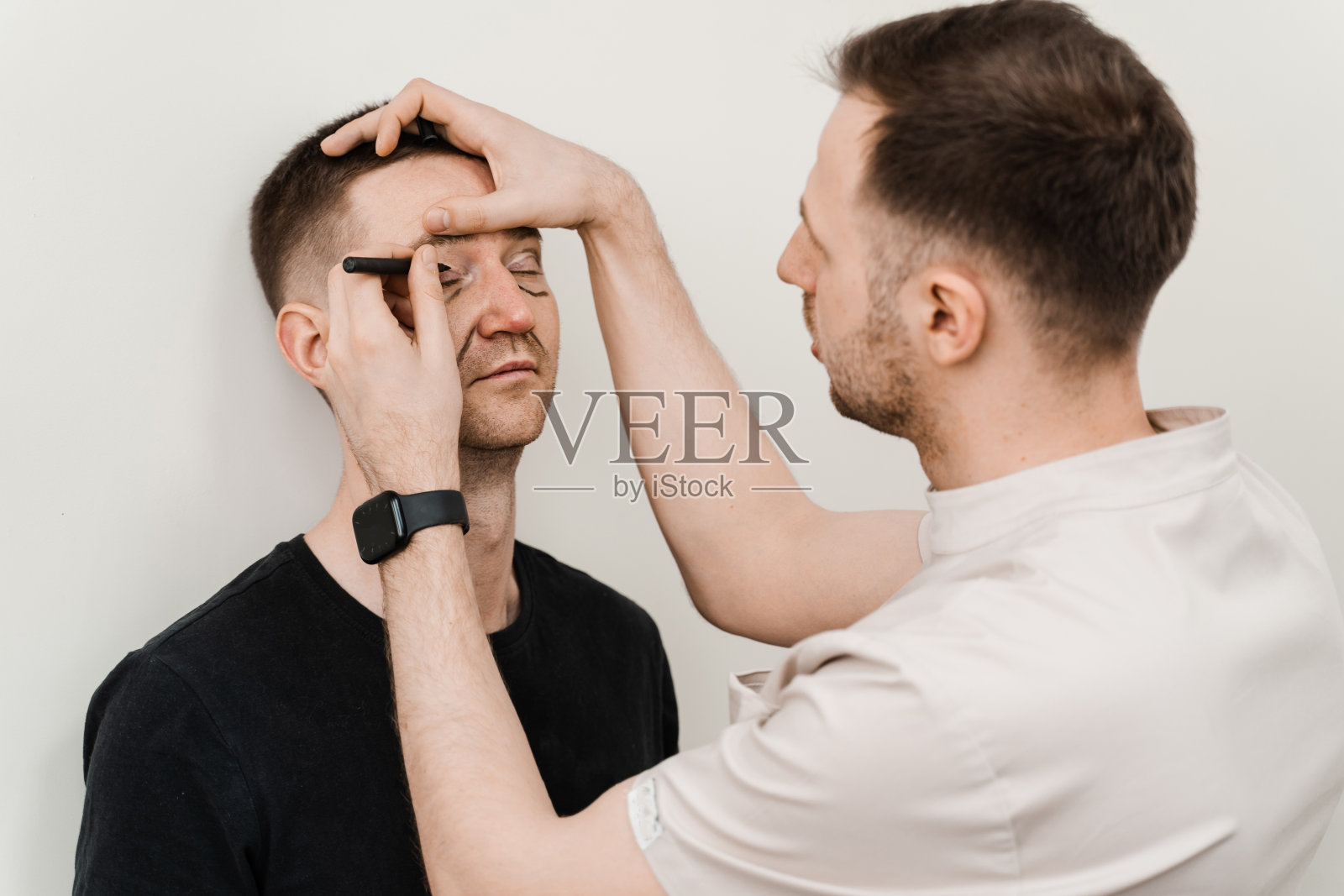 在医学诊所进行眼部整形手术前,对男性面部赘肉进行眼睑整形。照片摄影图片