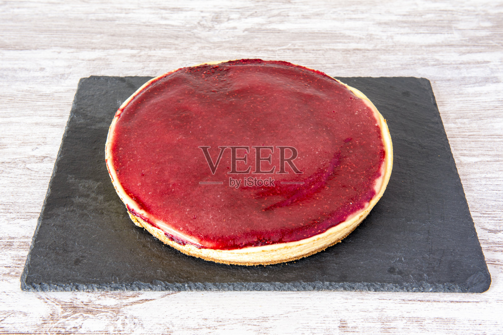 上面有覆盆子果酱的大芝士蛋糕照片摄影图片