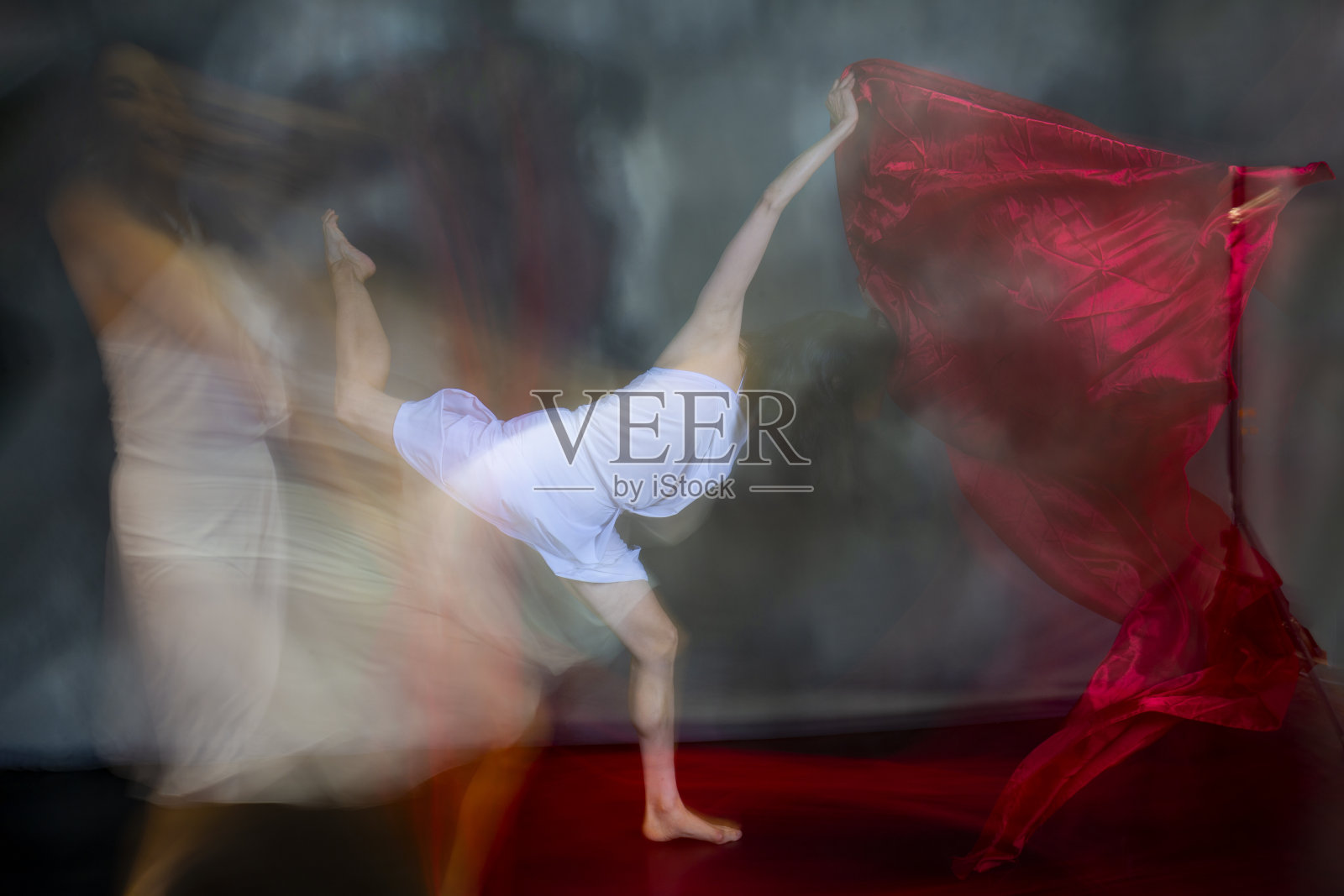 神秘的,模糊的舞蹈照片的成年妇女与彩色织物。照片摄影图片