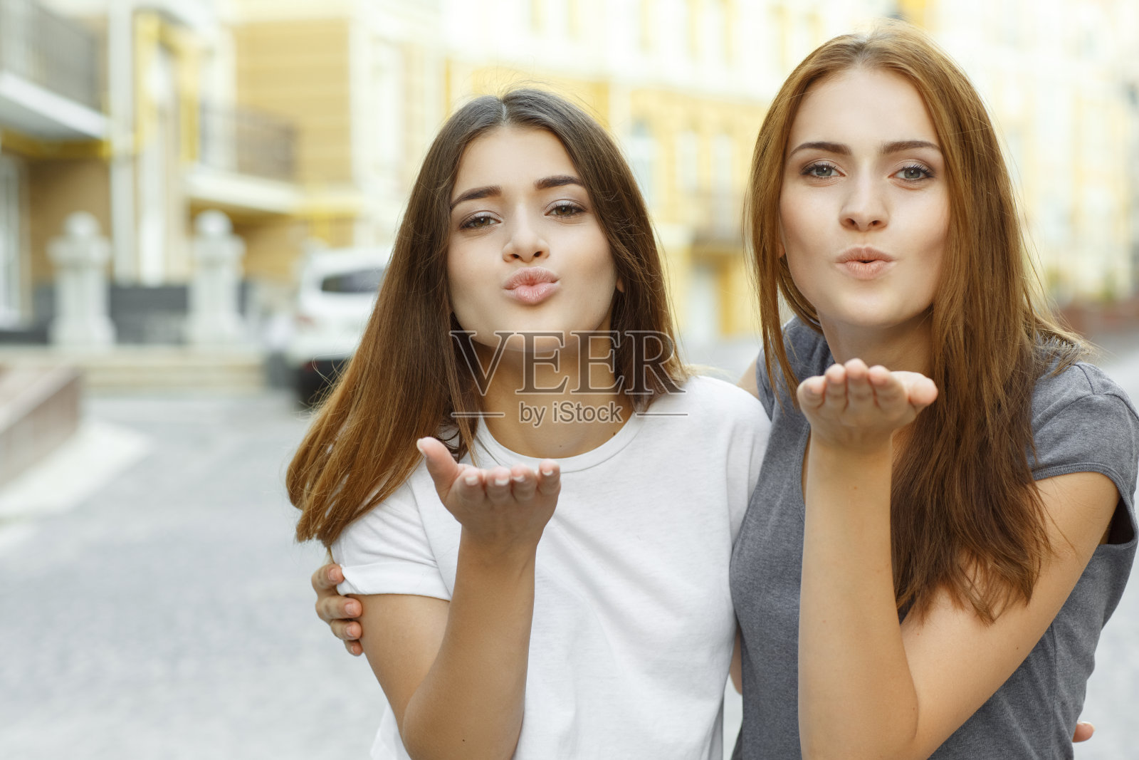 快乐的女性朋友在镜头前摆姿势亲吻照片摄影图片