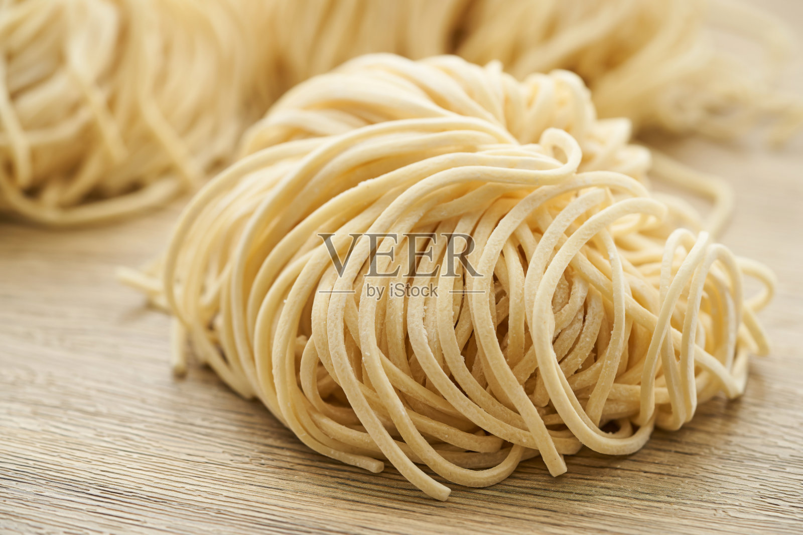 生拉面在木桌背景木板。新鲜鸡蛋拉面和木制背景。照片摄影图片