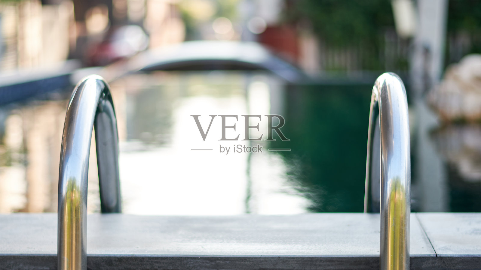 在柔焦背景中,泳池台阶或梯子的特写照片摄影图片