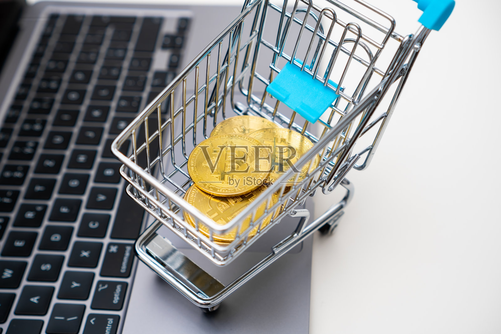 玩具购物车的俯视图,电脑上放着比特币照片摄影图片