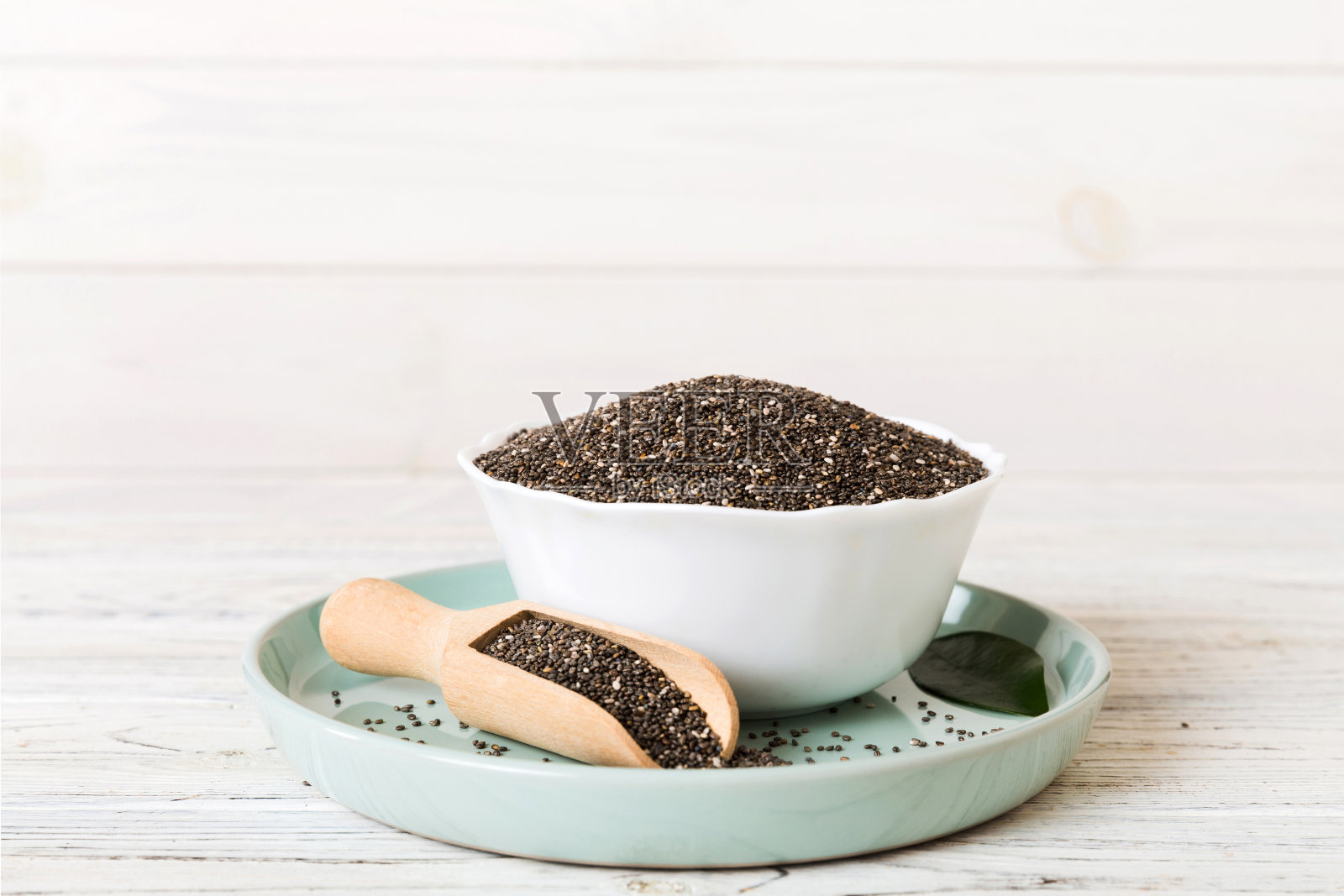 奇亚籽在碗和勺子在彩色背景。小碗里的健康鼠尾草。健康的超级食物照片摄影图片