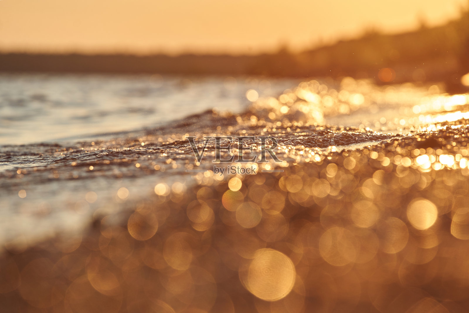 小波浪在落日的余晖中照亮了湖的黄金时刻照片摄影图片