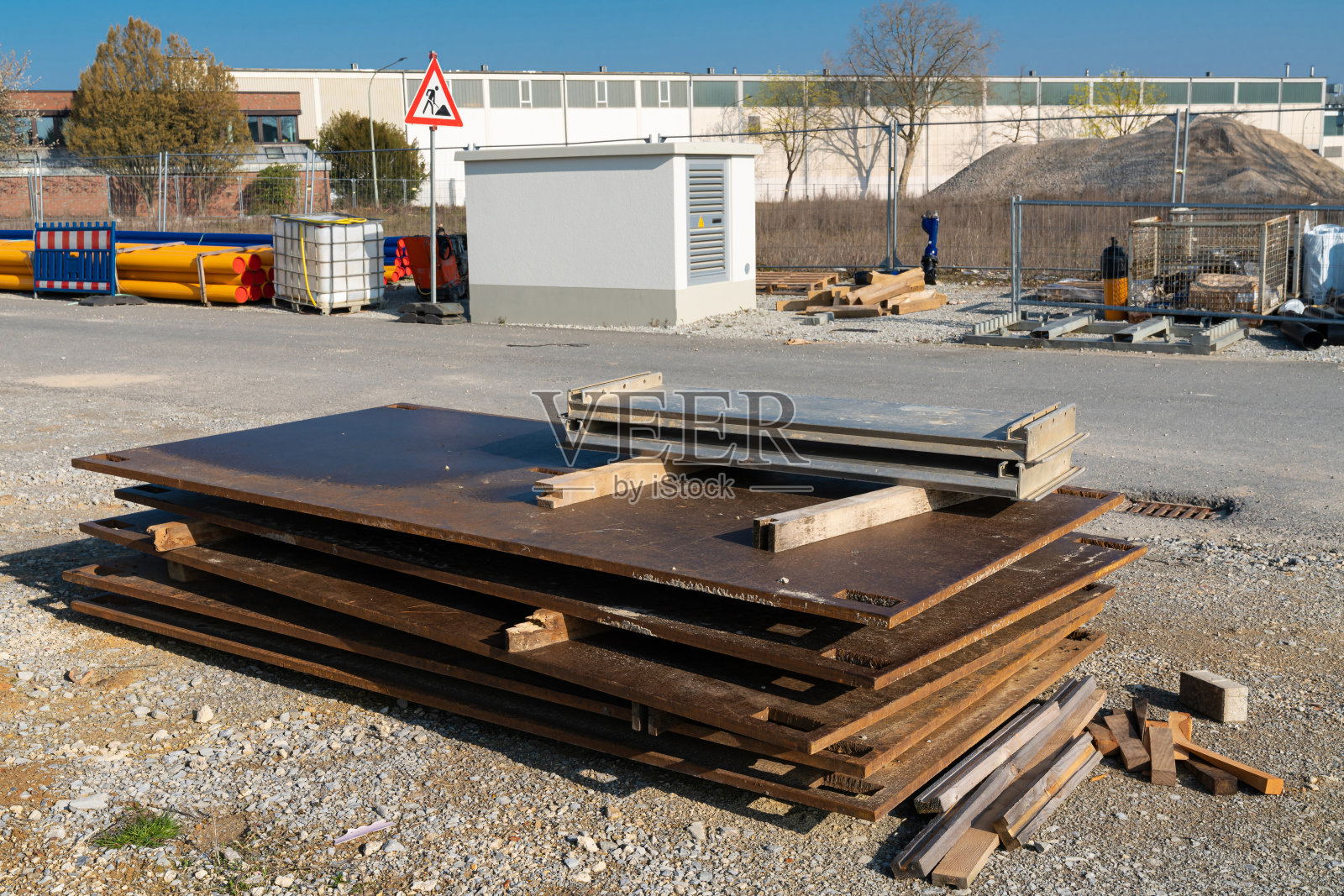 厚厚的、生锈的金属板堆积在建筑工地上。照片摄影图片