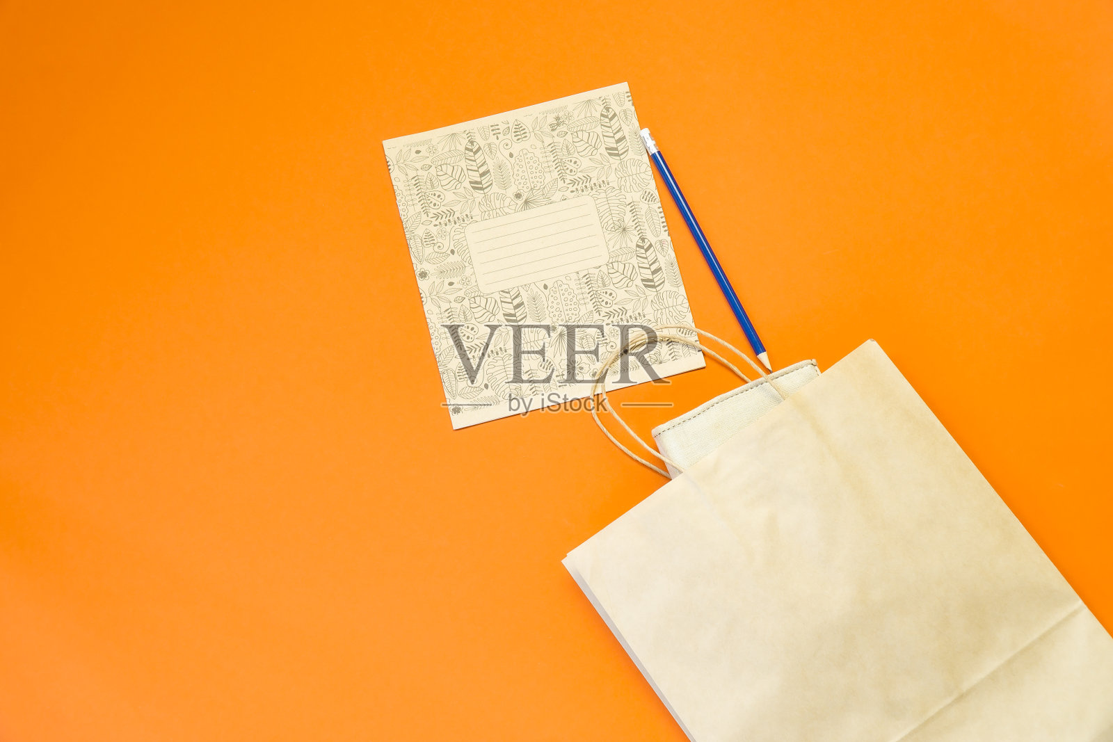 俯视图牛皮纸购物袋彩色背景,模拟空白牛皮纸购物袋和复制空间。平的。照片摄影图片