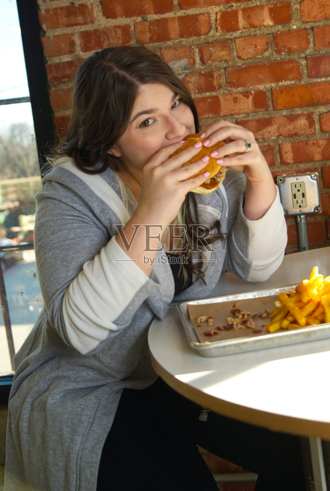 吃烧烤三明治的女人看着镜头照片摄影图片