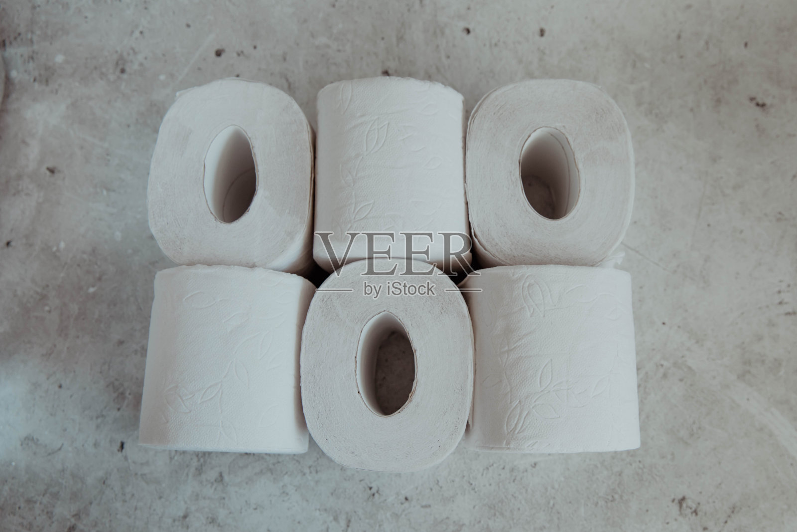 灰色灯光背景上的一叠厕纸卷照片摄影图片