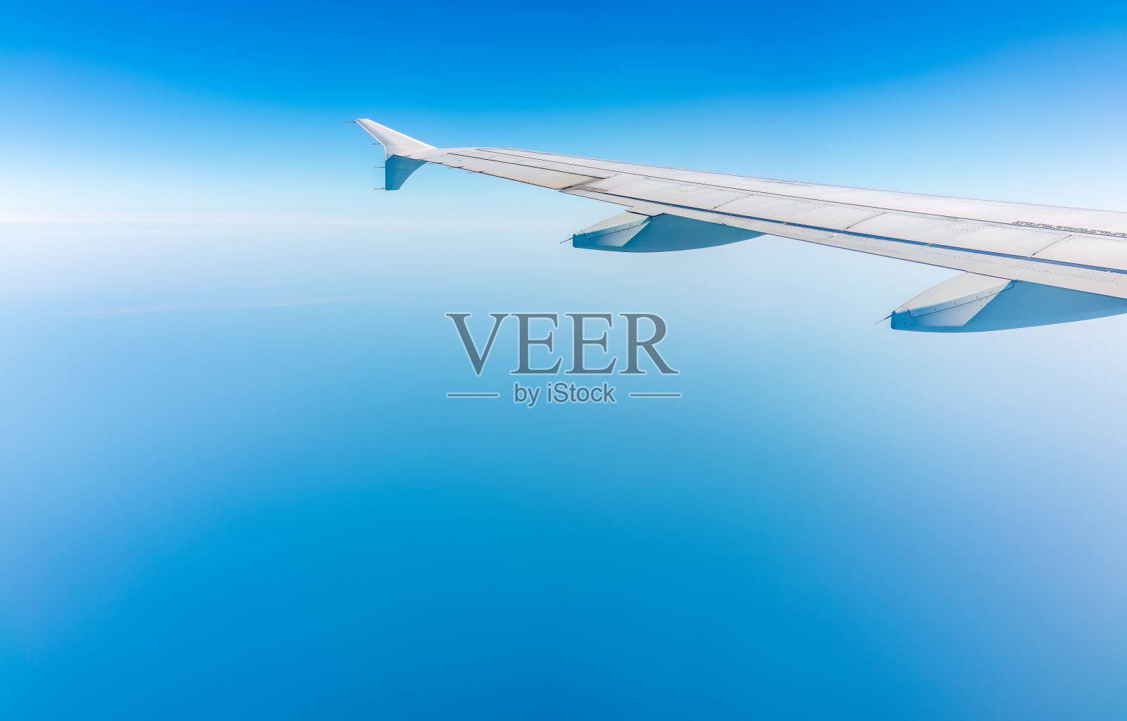 从飞机窗口看到美丽多云的天空和飞机的机翼照片摄影图片