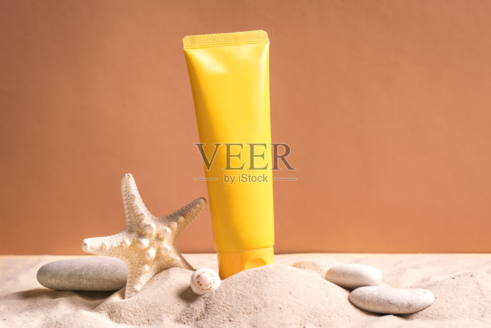 防晒霜,海星和沙滩上的鹅卵石照片摄影图片