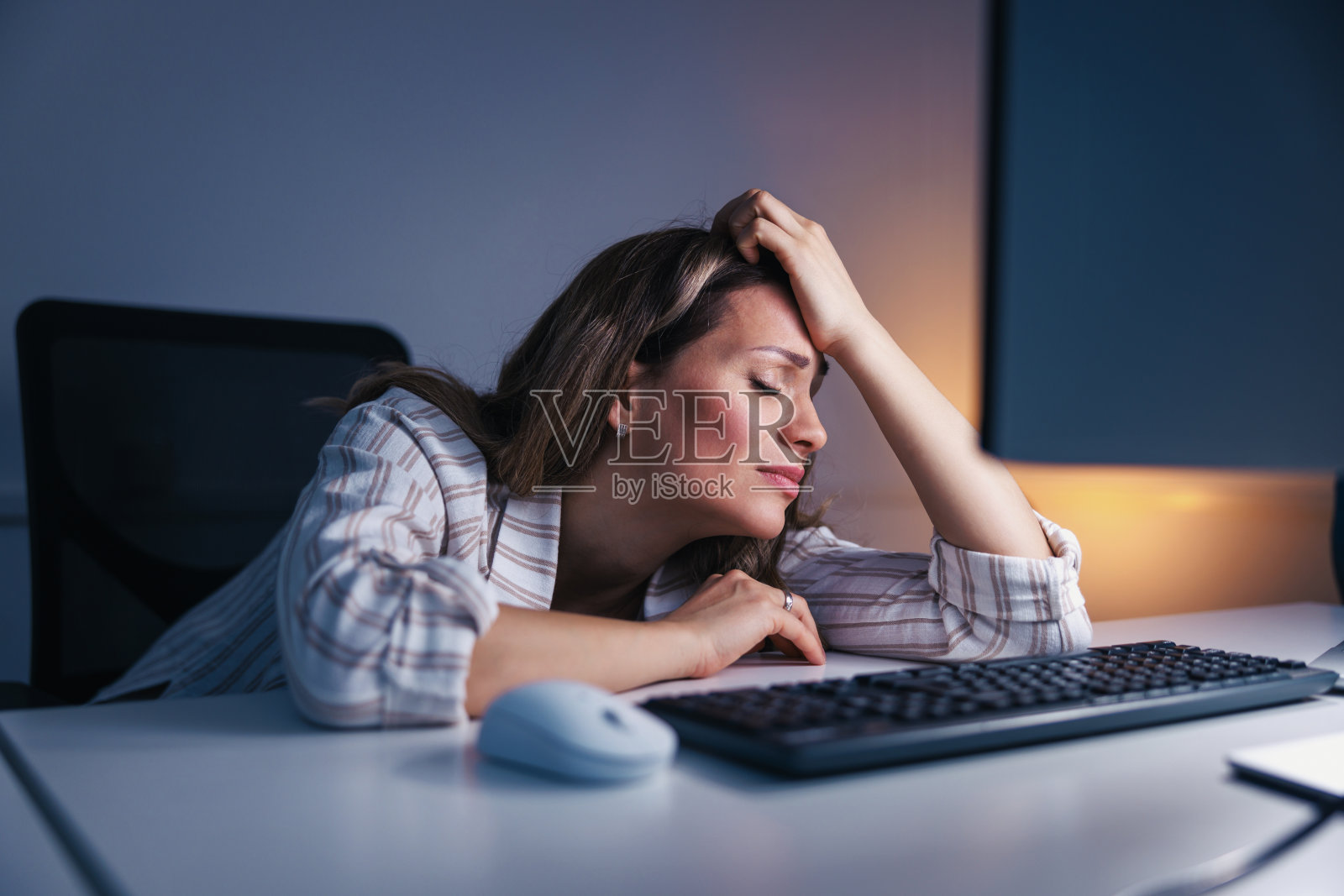 在办公室工作到很晚的女人很焦虑照片摄影图片