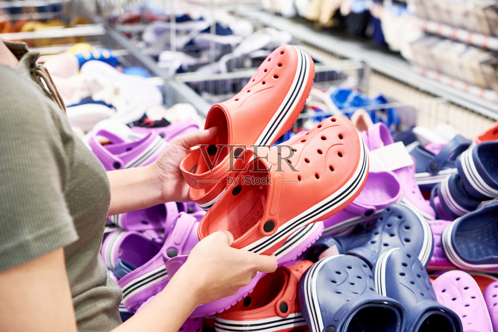 一位女士在商店挑选塑料拖鞋照片摄影图片