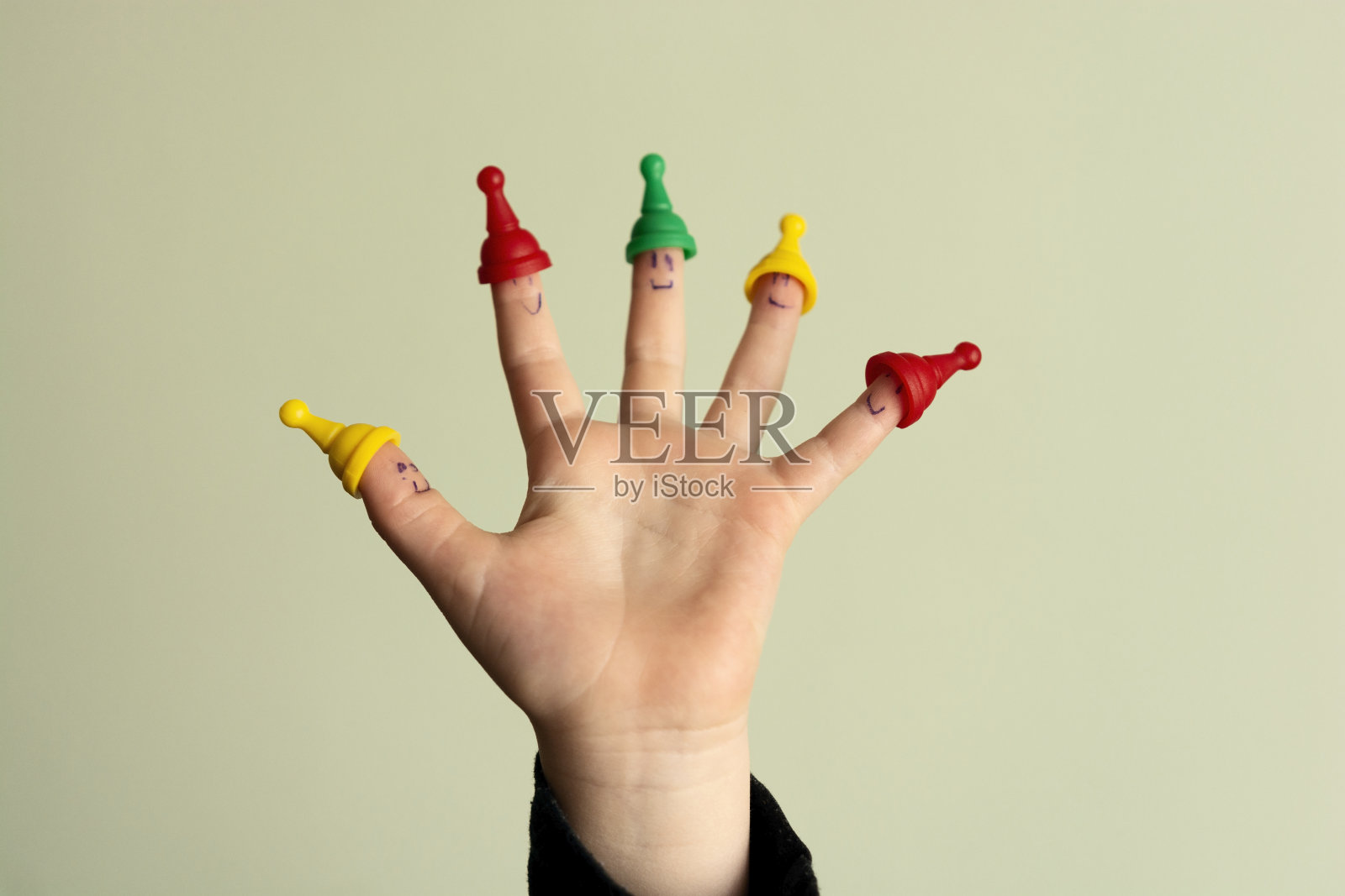 可爱的孩子手指白色的笑脸和塑料玩具照片摄影图片