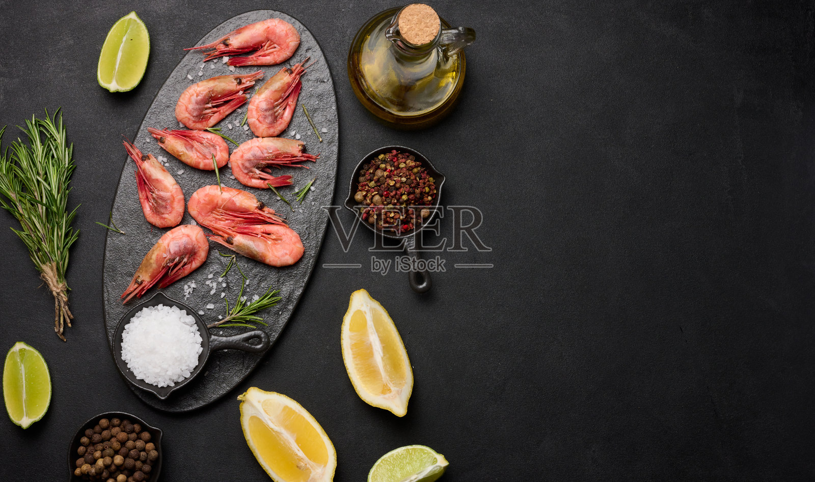 水煮虾在板上,柠檬片,香料在黑色背景,俯视图照片摄影图片