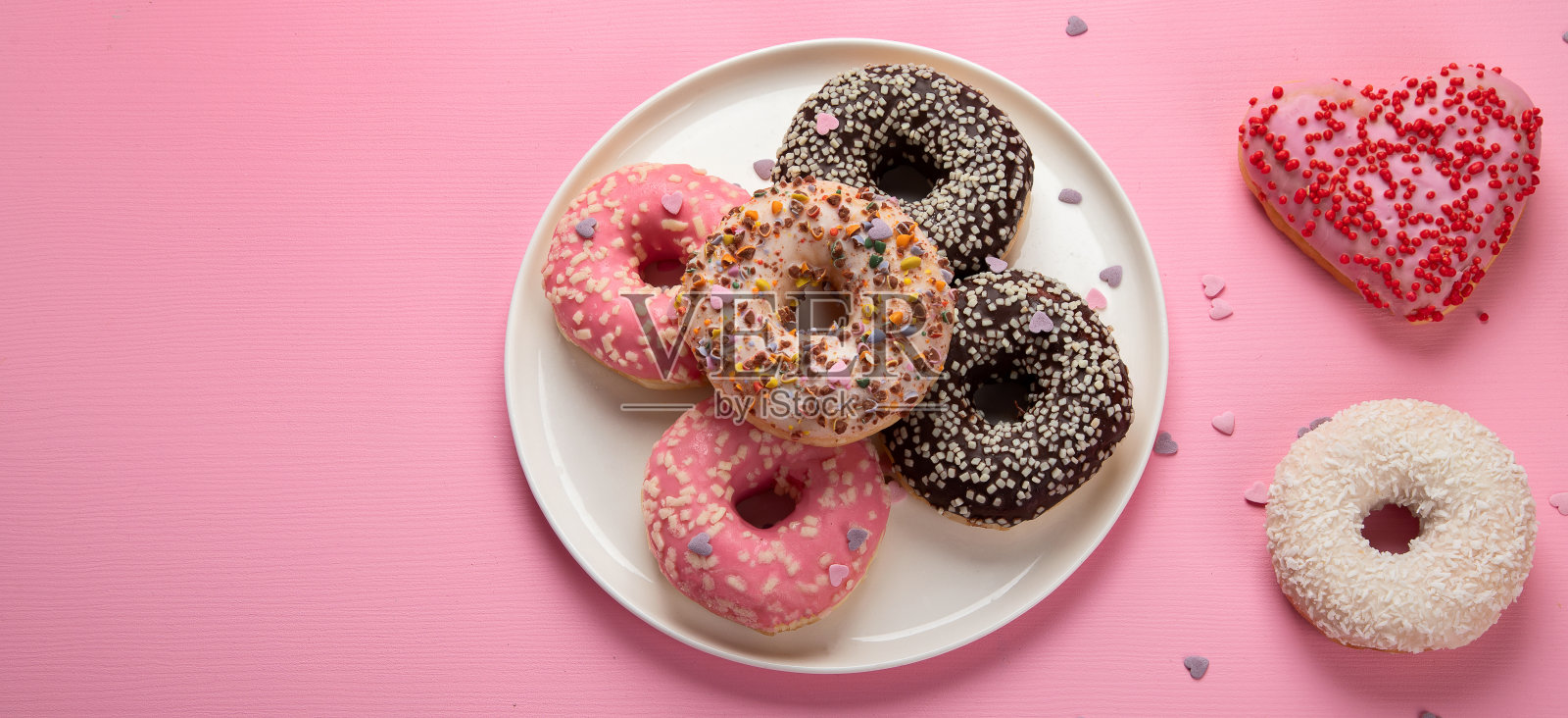 粉色背景上美味的甜甜圈。全国甜甜圈日。照片摄影图片