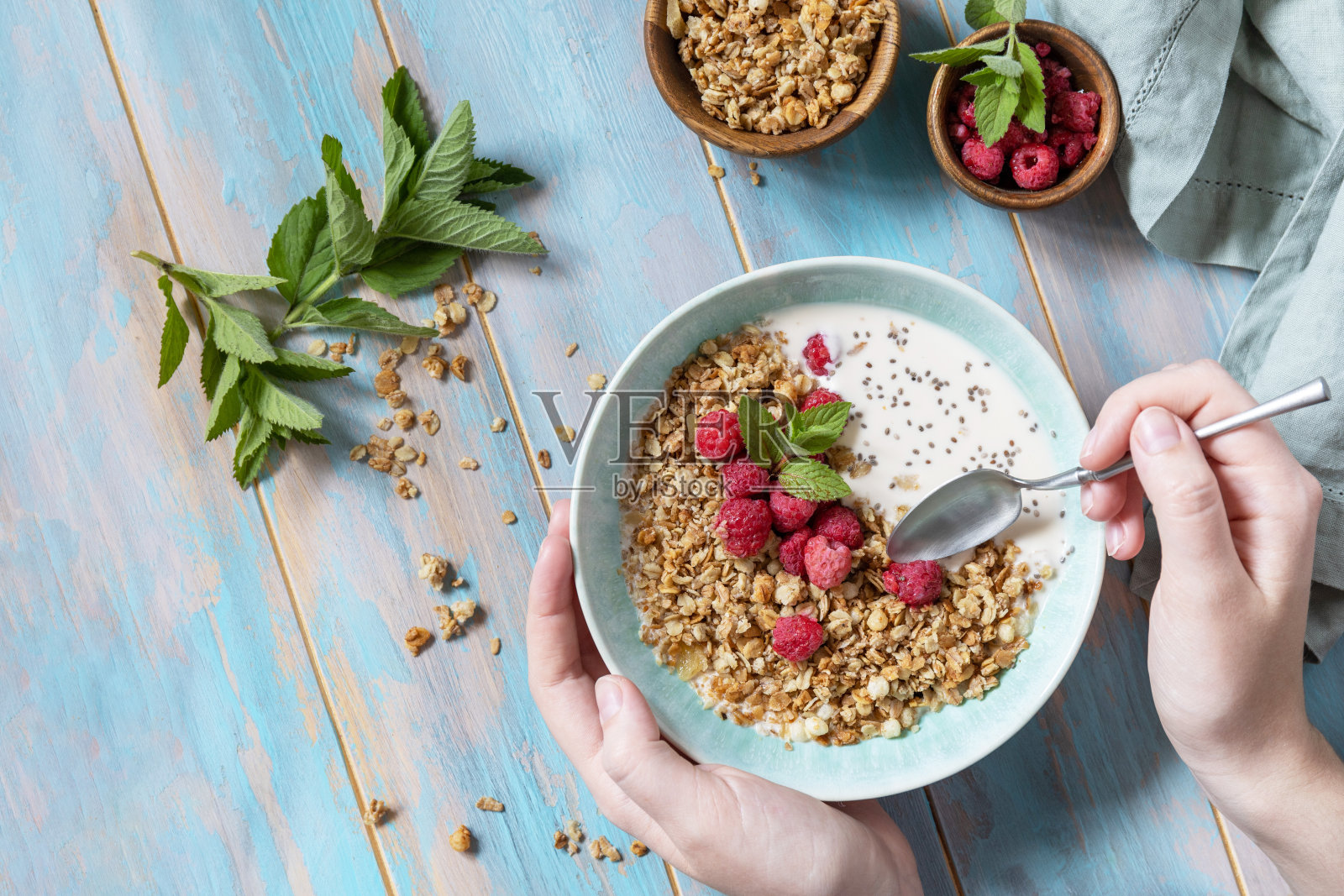 健康的早餐麦片碗自制的格兰诺拉麦片配上新鲜的覆盆子和奇亚籽放在质朴的桌子上。饮食营养理念。从上面看。照片摄影图片