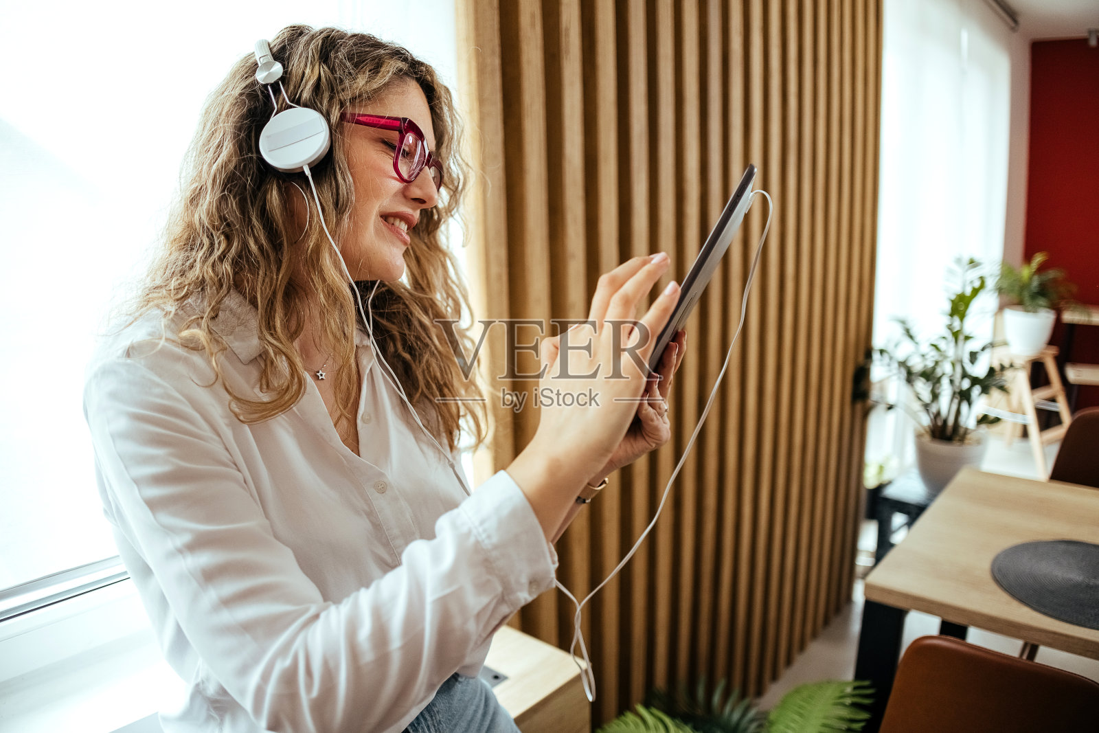 一个女人用她的数码平板电脑听音乐照片摄影图片