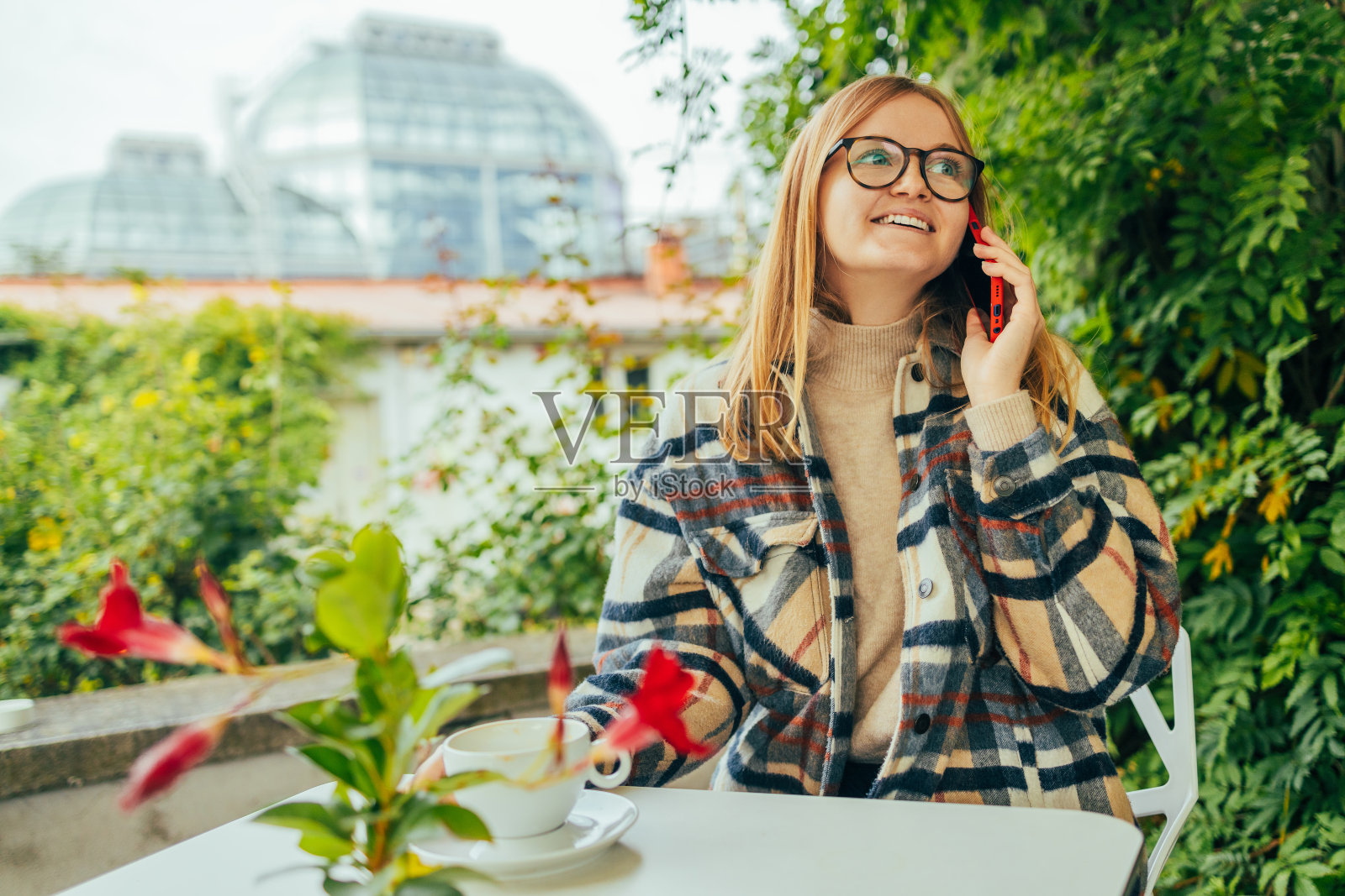 年轻迷人的女人在空闲时间独自坐在咖啡店用手机打电话,迷人的女人带着可爱的微笑在咖啡馆休息时用手机聊天照片摄影图片
