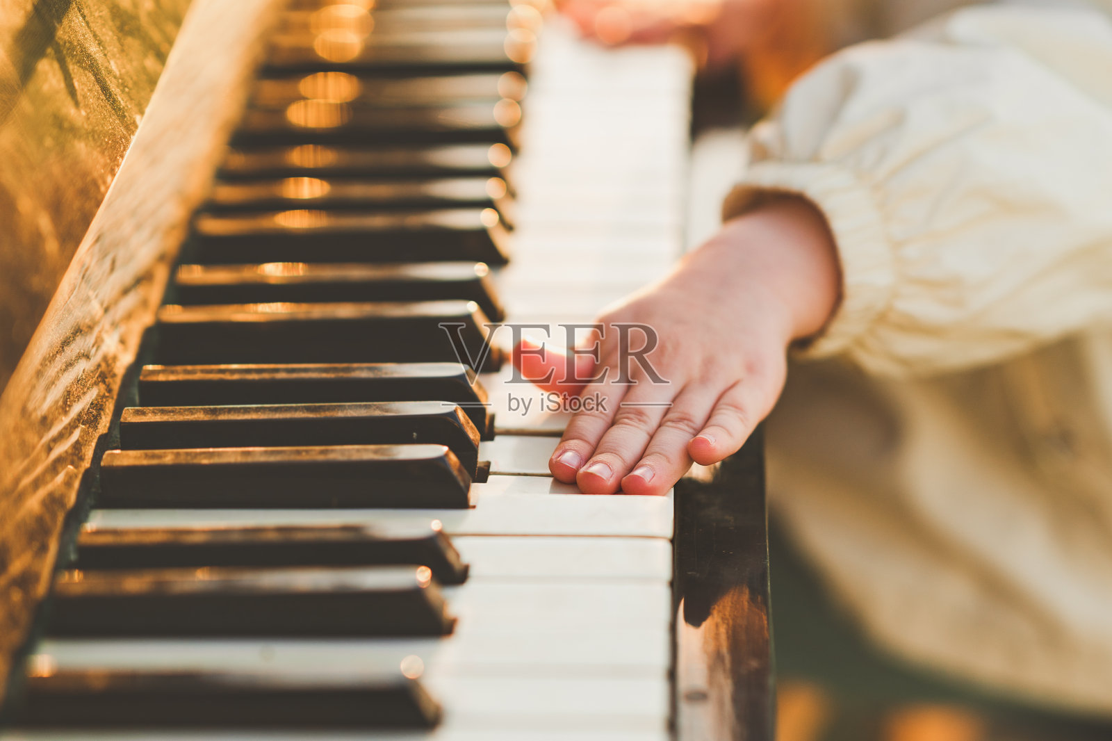 小女孩弹钢琴的手特写。照片摄影图片