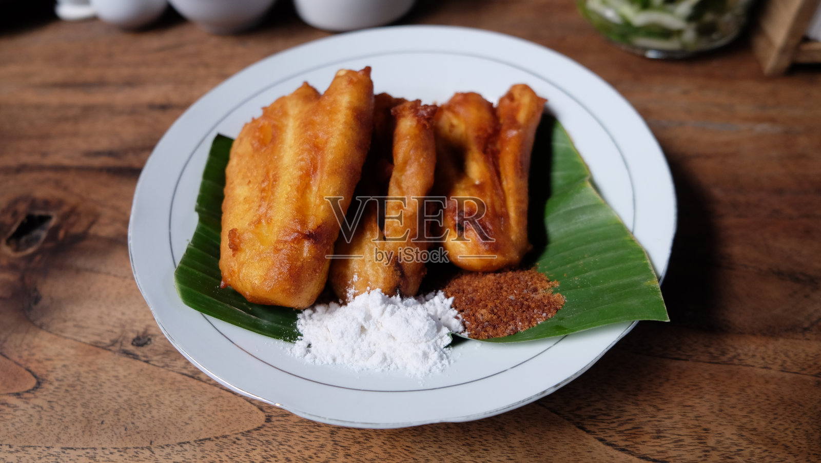 美味的炸香蕉或pisang goreng与白糖和红糖粉照片摄影图片