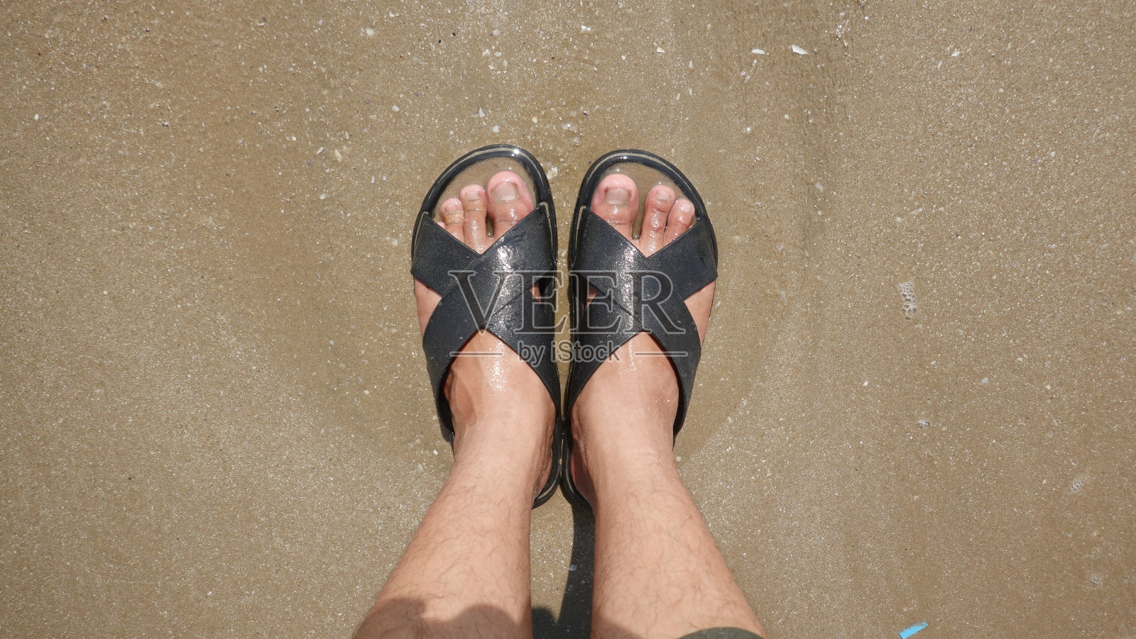 沙滩上的黑色凉鞋照片摄影图片