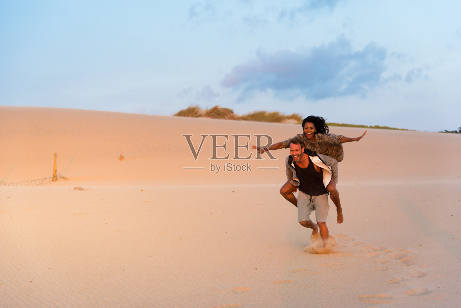 在沙滩上笑着玩背脊游戏照片摄影图片