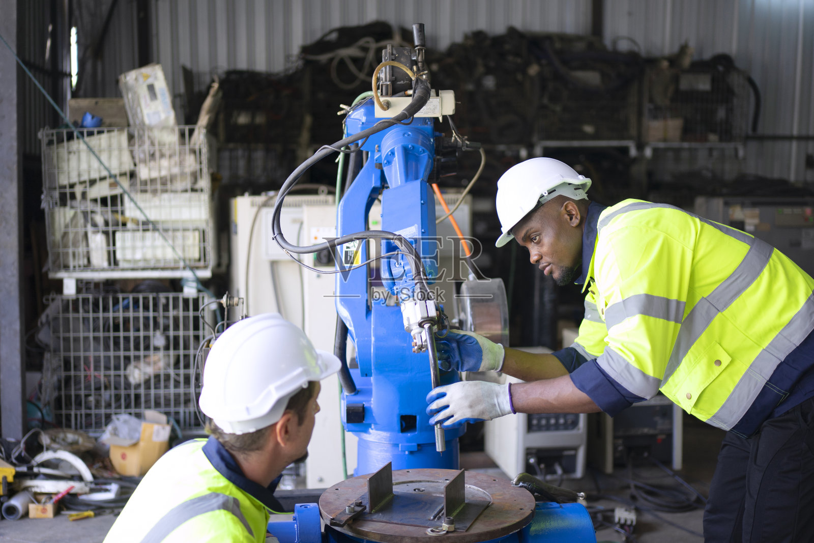 工程师在机械臂工厂工作。照片摄影图片