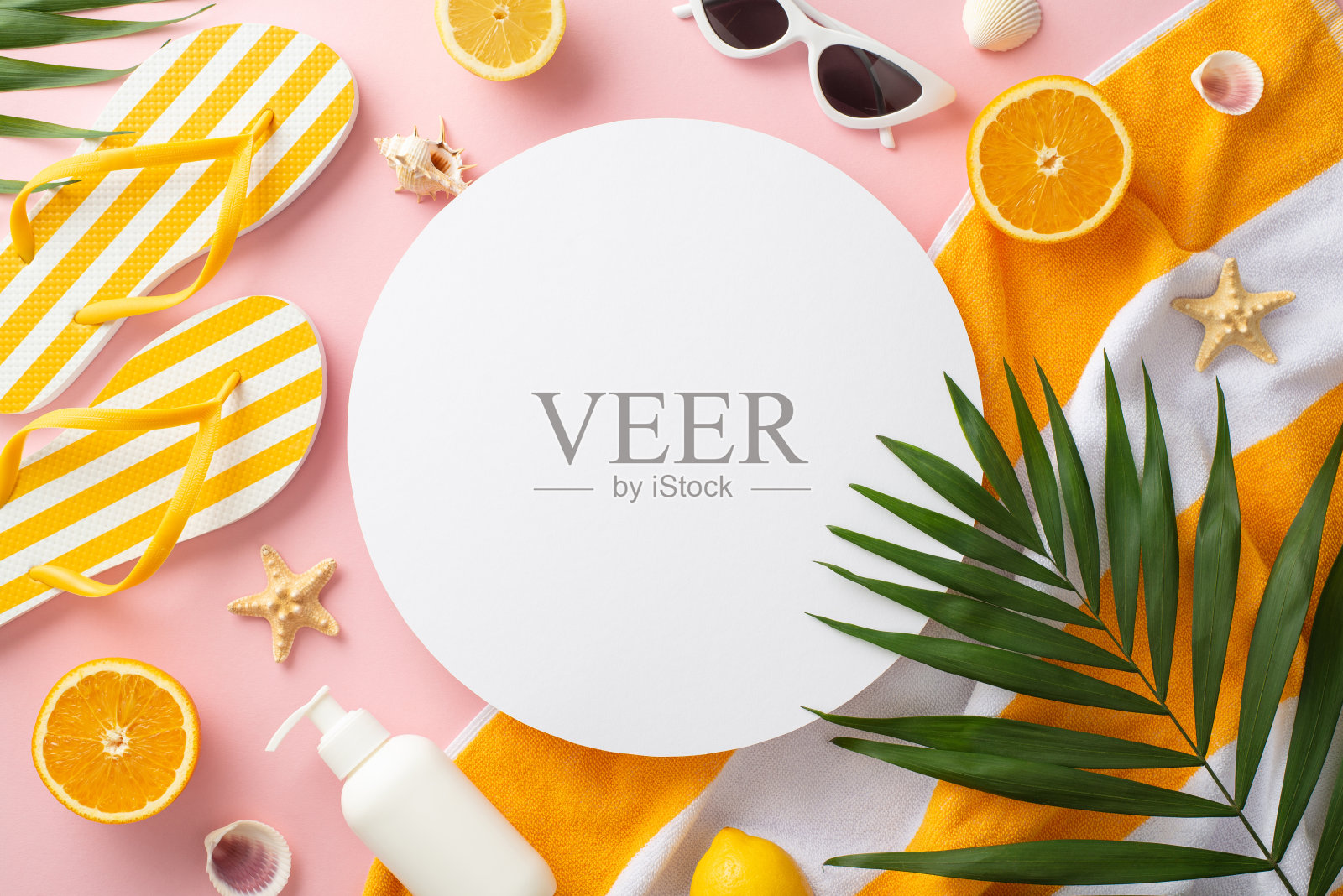 假期模式开启!顶视图平坦的条纹黄色拖鞋绿色棕榈叶,耳环,手镯和太阳镜毛巾在柔和的粉红色背景与空圈文字或广告照片摄影图片