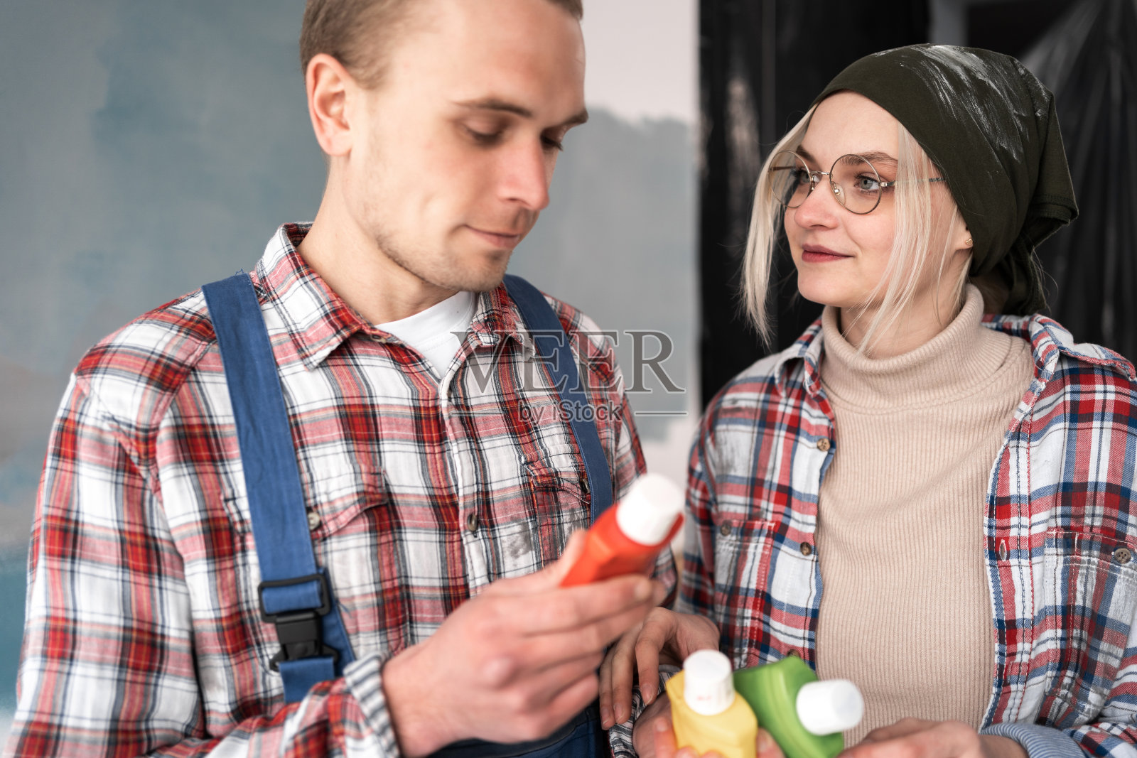 一对夫妇在家里看颜色样品。维修、室内设计、家居装修照片摄影图片