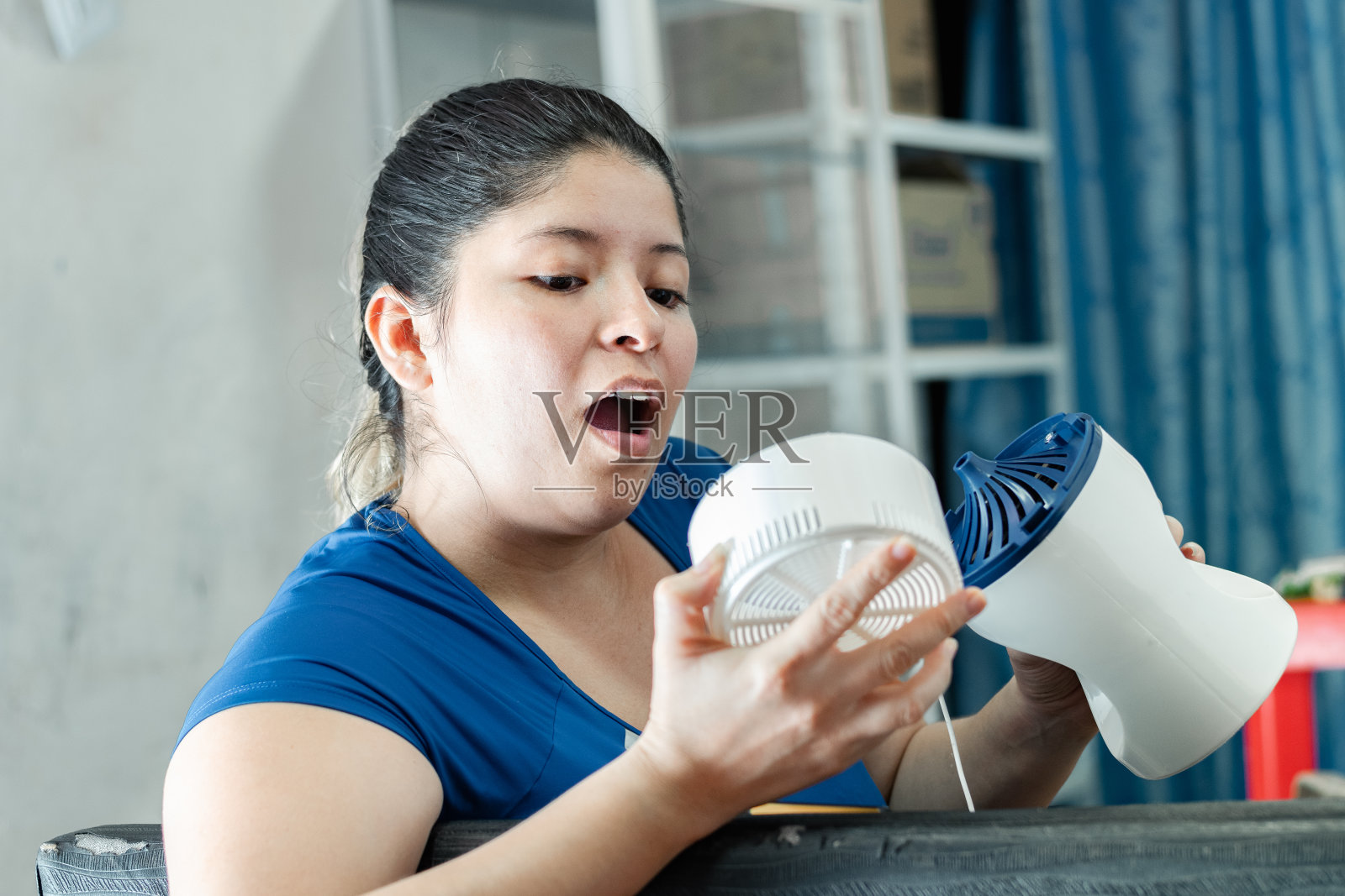 年轻的拉丁裔女子非常惊讶地看着扇子里面的样子照片摄影图片