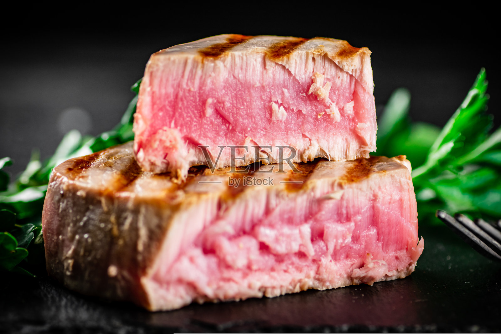 桌上有烤金枪鱼配欧芹。照片摄影图片