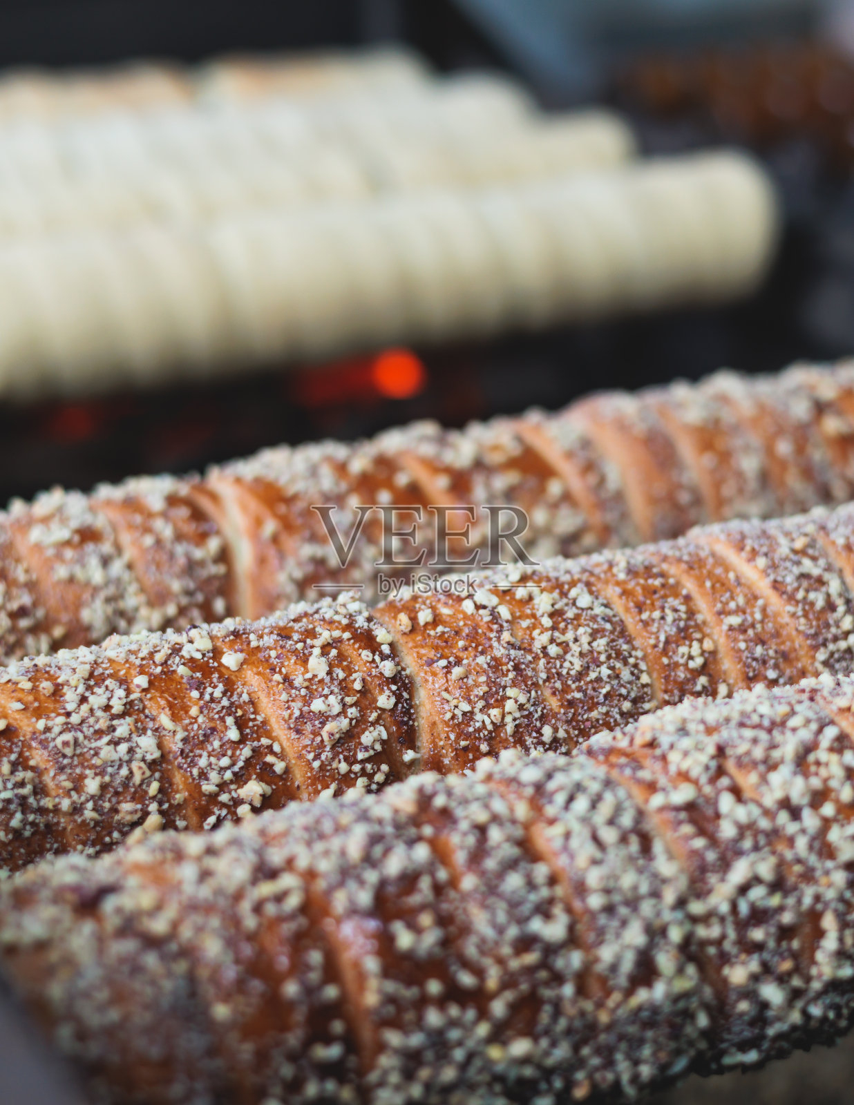 Trdelnik,捷克和欧洲传统的甜街头食品,在街头美食节市场上的烘烤和烹饪过程照片摄影图片