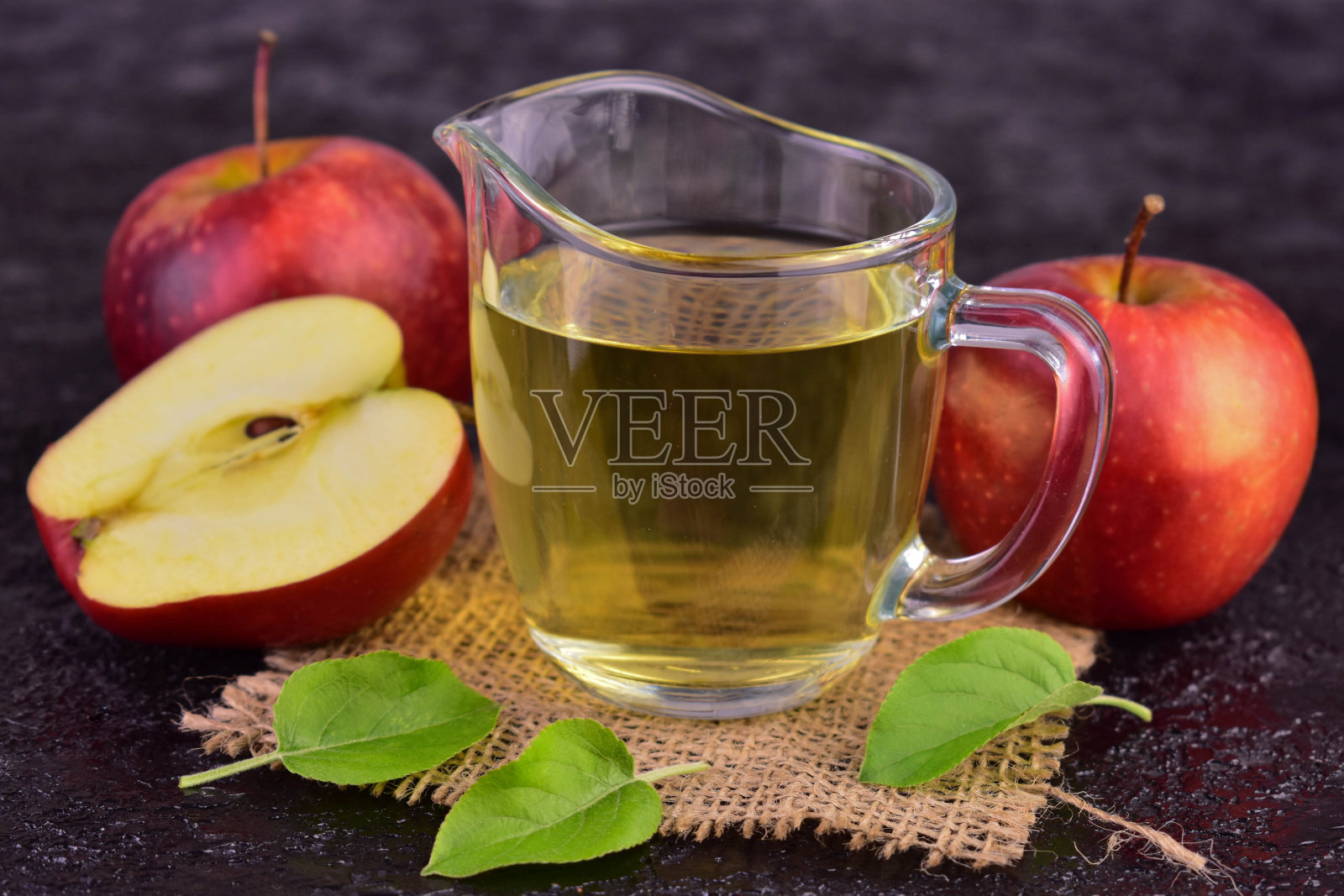 黑色背景上的苹果醋和新鲜苹果。特写。照片摄影图片